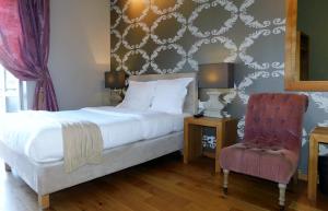 a bedroom with a bed and a chair at Hotel De La Mer in Nice