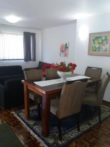 a dining room table with chairs and a bowl of flowers on it at Casa com garagem em condomínio in Curitiba