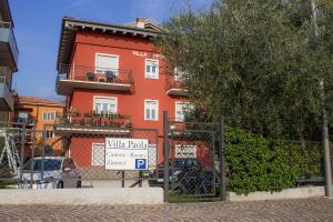 un edificio rojo con un cartel delante en Villa Paola B&B, en Nago-Torbole