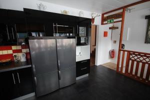 a kitchen with black cabinets and a stainless steel refrigerator at Hamrahl&iacute;&eth; 9 Guesthouse in Grundarfjordur