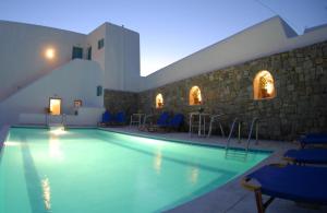 una piscina en un edificio con sillas azules en Asteri Hotel en Ornos
