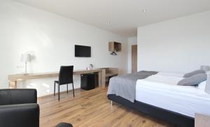 a bedroom with a bed and a desk with a chair at Hafdals Hotel in Akureyri