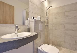 a white bathroom with a sink and a toilet at Hafdals Hotel in Akureyri