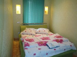 ヘルソンにあるMaxim Apartmentのベッドルーム1室(ピンクの花が咲くベッド1台付)