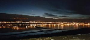 a view of a city at night from the water at Hafdals Hotel in Akureyri