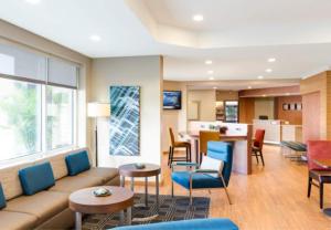 a living room with a couch and chairs and a kitchen at TownePlace Suites by MarriottDetroit Canton in Canton