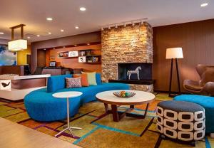 a living room with blue furniture and a fireplace at Fairfield Inn & Suites by Marriott Detroit Canton in Canton