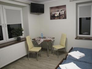 a room with a table and chairs and a bed at Heveliusz in Sokołów Podlaski
