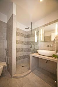La salle de bains est pourvue d'une baignoire, d'un lavabo et d'une douche. dans l'établissement Aelia Apartments, à Naxos Chora