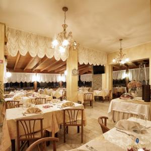 un ristorante con tavoli, sedie e lampadario a braccio di Hotel Italia a Lerici