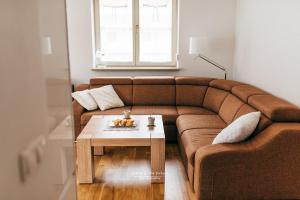 sala de estar con sofá marrón y mesa en Apartament 3 - Bliżej Zdroju en Polanica-Zdrój