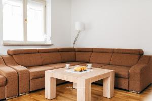 a living room with a brown couch and a coffee table at Apartament 3 - Bliżej Zdroju in Polanica-Zdrój