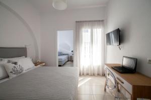 1 dormitorio con cama y escritorio con ordenador portátil en Aelia Apartments, en Naxos Chora