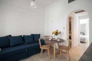 a living room with a blue couch and a table at Aelia Apartments in Naxos Chora