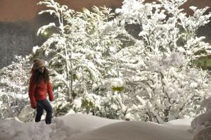 Una donna che cammina attraverso un cumulo di neve di Cabañas Las Aguilas ADHERIDA PREVIAJE a Ushuaia