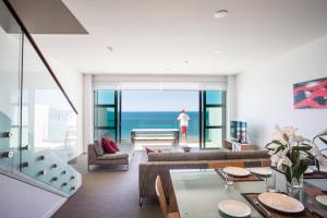 a living room with a view of the ocean at Doubtless Bay Villas in Cable Bay