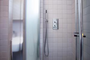 a shower in a bathroom with white tiles at Chambre d'hôte parisienne in Paris +15 photos