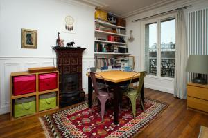 a dining room with a table and chairs on a rug at Chambre d'hôte parisienne in Paris