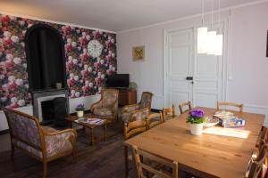 a living room with a table and a fireplace at Domaine des Lilas in Saint-Germain-Lembron