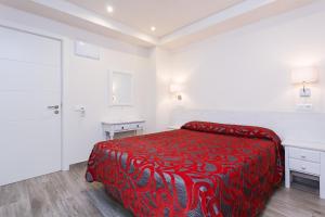 a bedroom with a red bed and a desk at Hostal Sol y Miel in Benalmádena