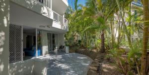 a house with a patio with palm trees at Santa Anne By The Sea in Gold Coast