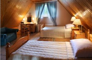 a attic bedroom with two beds and a window at Pensjonat Mijamar in Białogóra