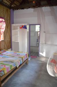 a bedroom with a bed and a fan at Sablayan Paraiso Beach Resort in Sablayan