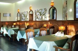 a dining room with green tables and chairs and mirrors at Pensjonat Mijamar in Białogóra