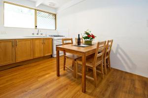a kitchen with a table with chairs and a bottle of wine at Peppermint Brook Cottages in Margaret River Town