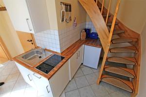 eine kleine Küche mit einem Waschbecken und einer Treppe in der Unterkunft Ferienhaus Ribnitz MOST 751 in Ribnitz-Damgarten