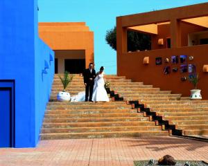 a bride and groom standing on the steps of a building at Hotel de Naturaleza Rodalquilar & Spa Cabo de Gata in Rodalquilar