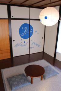 um quarto com uma mesa, uma janela e um candeeiro em Guest House Shimayado Aisunao em Naoshima