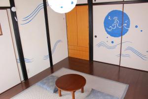 een kamer met een houten tafel en een kruk bij Guest House Shimayado Aisunao in Naoshima