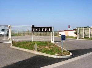 una señal de hotel frente a una pista de tenis en L'Epicurien, en Saint-Nicolas-de-Port