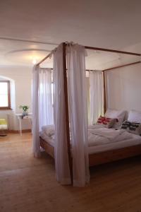 a bedroom with a bed with a canopy at Historisches Pfarrhaus Nähe Schloss Neuschwanstein in Burggen