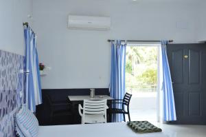 a bedroom with blue curtains and a table and chairs at Quiet Home in Puducherry