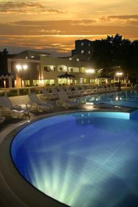 a large swimming pool at night with lounge chairs at Hotel Portonuovo in Vieste