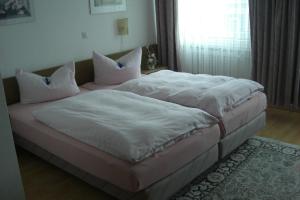 1 dormitorio con 1 cama grande con sábanas blancas y almohadas en Hotel Solinger Hof, en Solingen