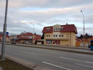 a building with a red roof on the side of a street at Penzion Maja in Martin