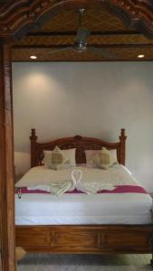 1 dormitorio con 1 cama con marco de madera en Bagus Homestay, en Ubud