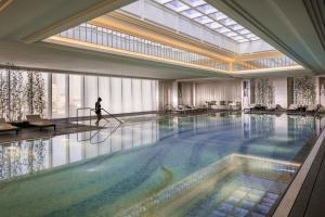 a person is standing in a large swimming pool at Four Seasons Hotel Tianjin in Tianjin