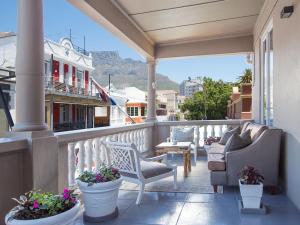 un porche con 2 sillas y un sofá en el balcón en Long Street Boutique Hotel en Ciudad del Cabo