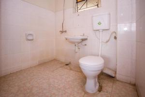 a bathroom with a toilet and a sink at Hotel Genevieve in Nakuru