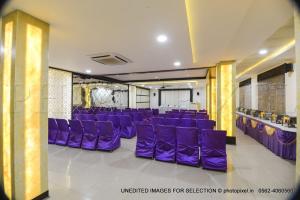 a conference room with purple chairs and a podium at Palm Galaxy in Itimādpur