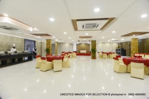 a banquet hall with yellow and red tables and chairs at Palm Galaxy in Itimādpur
