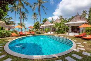 a pool at a resort with chairs and umbrellas at Secret Garden Beach Resort in Bangrak Beach