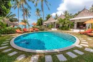 a pool at a resort with chairs and umbrellas at Secret Garden Beach Resort in Bangrak Beach