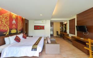 a bedroom with a large bed and a television at Sita Beach Resort in Ko Lipe