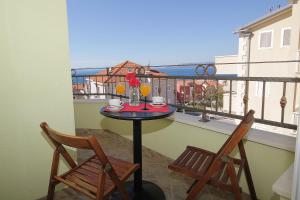 a table and two chairs on a balcony with a view at Apartments Adriatika in Makarska