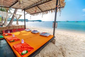 a table sitting on a beach with the ocean at Secret Garden Beach Resort in Bangrak Beach